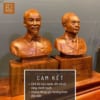 Hai bức tượng bán thân của chủ tịch Hồ Chí Minh và đại tướng Võ Nguyên Giáp. hai bức tượng được làm từ gỗ có màu nâu đỏ. Hai người mặc cái áo, có cổ áo bẻ ra. Hai bức tượng được đặt trên bực gỗ.