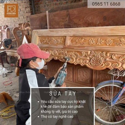 ảnh một người phụ nữ mặc áo lao động đang ngồi sửa cái bàn thờ được làm từ gỗ