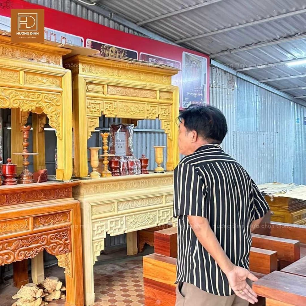 một người đàn ông đang đứng xem bàn thờ. Các bàn thờ được làm bằng gỗ, có màu sắc khác nhau như nâu đậm, nâu nhạt, nâu sáng